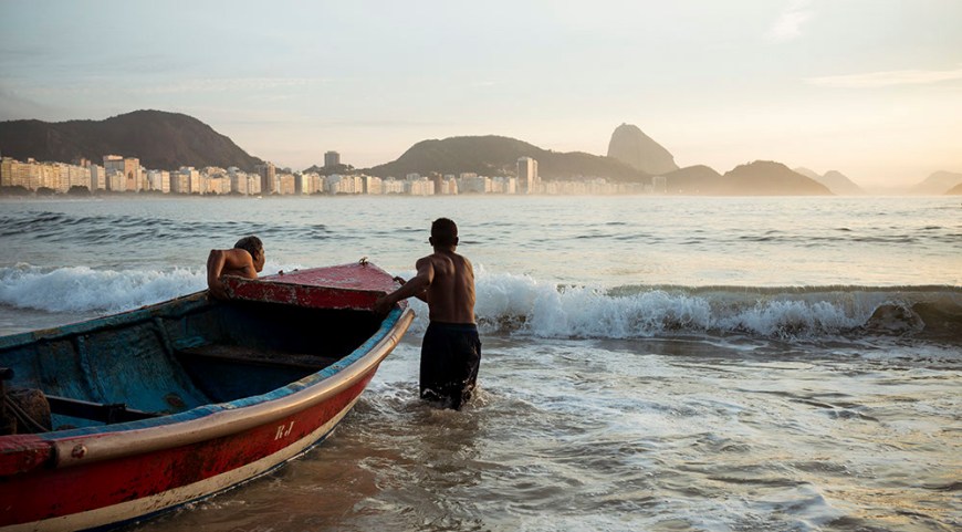 Fishermen taking their boat out at dawn, Copacabana, Rio de Janeiro, Brazil