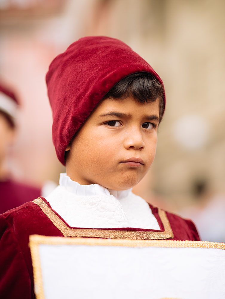 Boy in Medieval costume parading through the streets of Asti