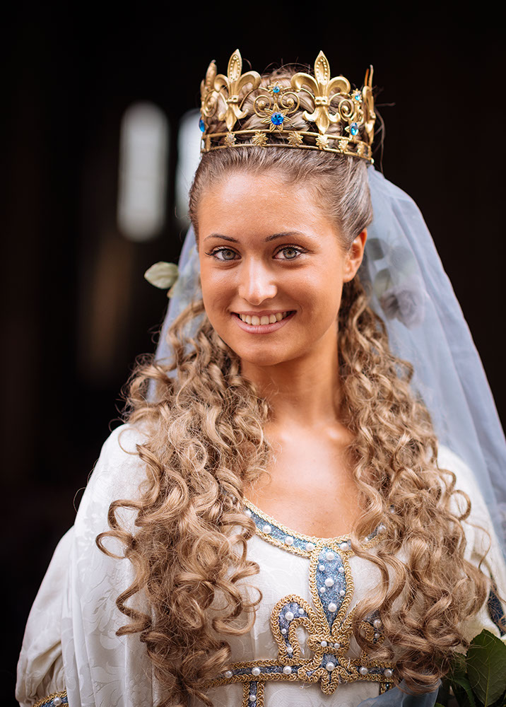Portrait of young woman in traditional medieval costume ahead of the Palio di Asti