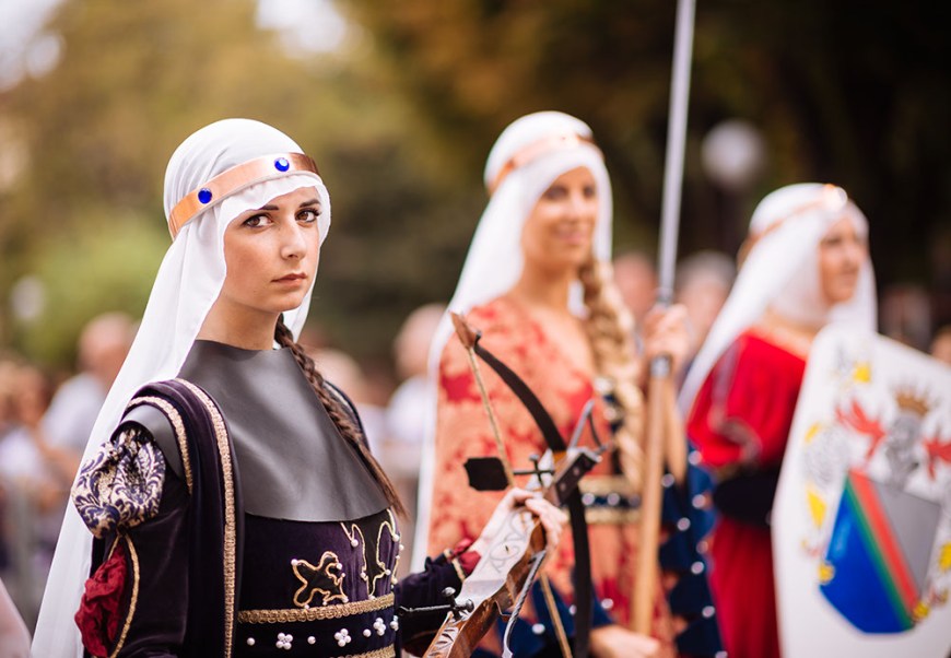Women in a medieval costume takes part in a historical parade from the Piazza Cattedrale to the race track ahead of the Palio Di Asti on September 21, 2014 in Asti, Italy