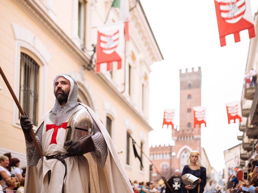 A man in a medieval costume takes part in a historical parade from the Piazza Cattedrale to the race track ahead of the Palio Di Asti on September 21, 2014 in Asti, Italy