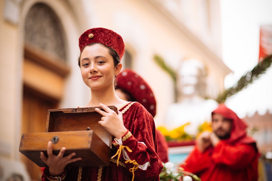 A girl in a medieval costume takes part in a historical parade from the Piazza Cattedrale to the race track ahead of the Palio Di Asti on September 21, 2014 in Asti, Italy
