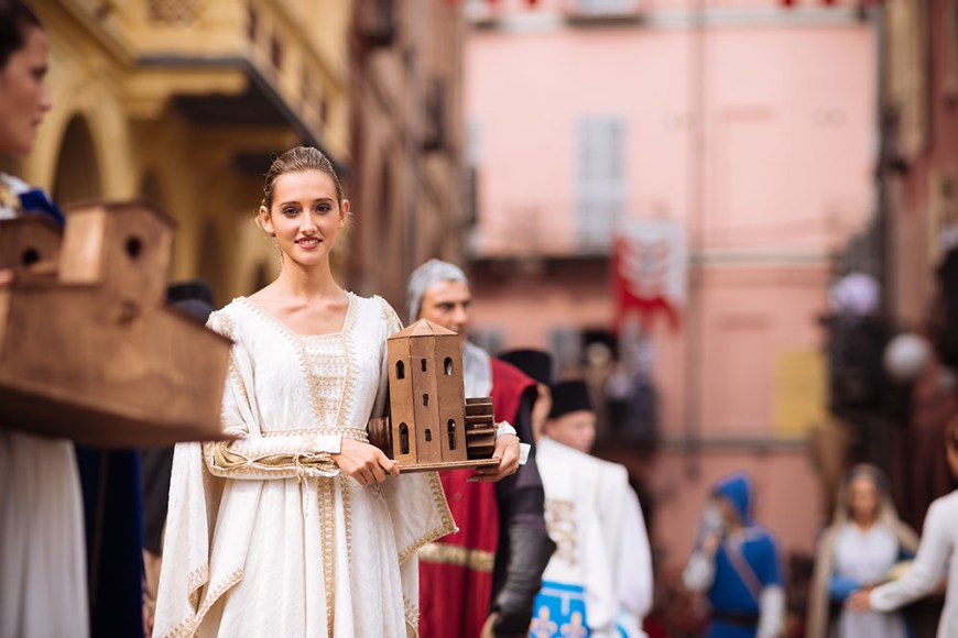 A girl in a medieval costume takes part in a historical parade from the Piazza Cattedrale to the race track ahead of the Palio Di Asti on September 21, 2014 in Asti, Italy
