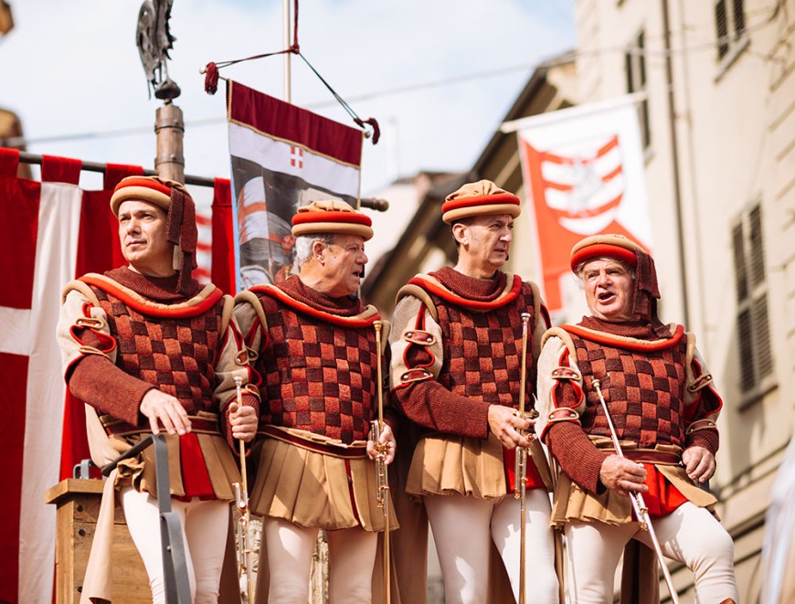 People in a medieval costume take part in a historical parade from the Piazza Cattedrale to the race track ahead of the Palio Di Asti on September 21, 2014 in Asti, Italy