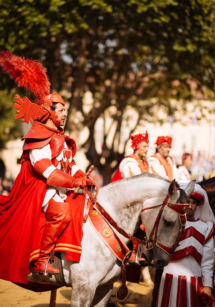 People in a medieval costume take part in a historical parade from the Piazza Cattedrale to the race track ahead of the Palio Di Asti on September 21, 2014 in Asti, Italy