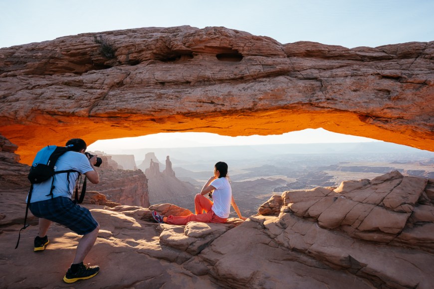 Tourists taking photographs, Mesa Arch at dawn, Canyonlands National Park, Utah, USA