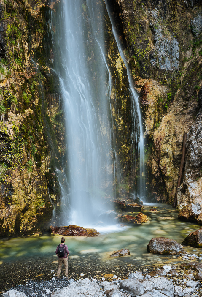 Man looking up at Theth Waterfall, Theth, The Accursed Mountains, Albania