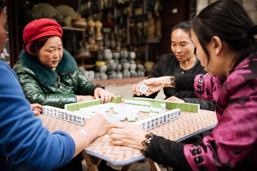 Women playing traditional Chinese game of Mahjong on street, Dali, Yunnan Province, China